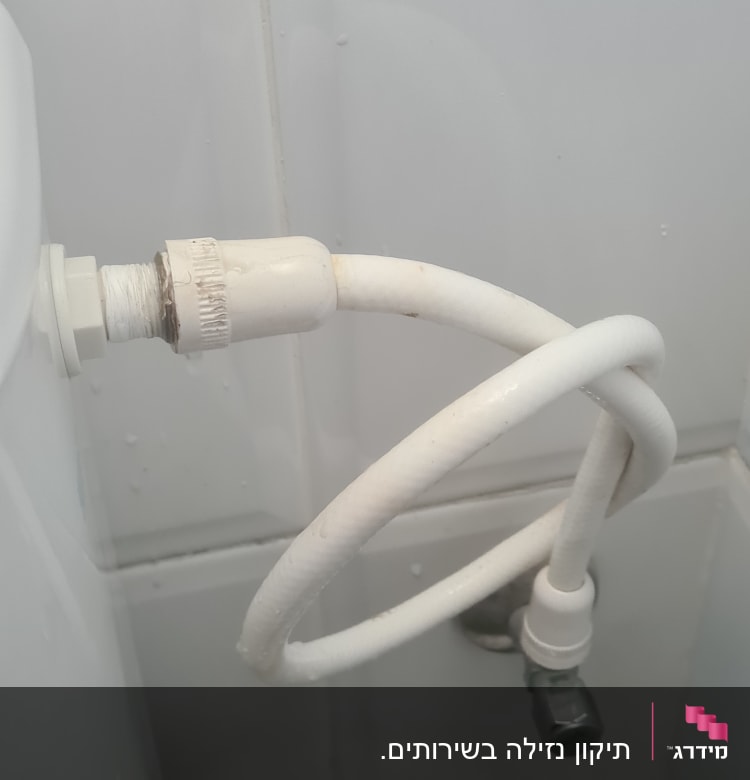 צינור מים לבן מחובר לקיר עם ברז